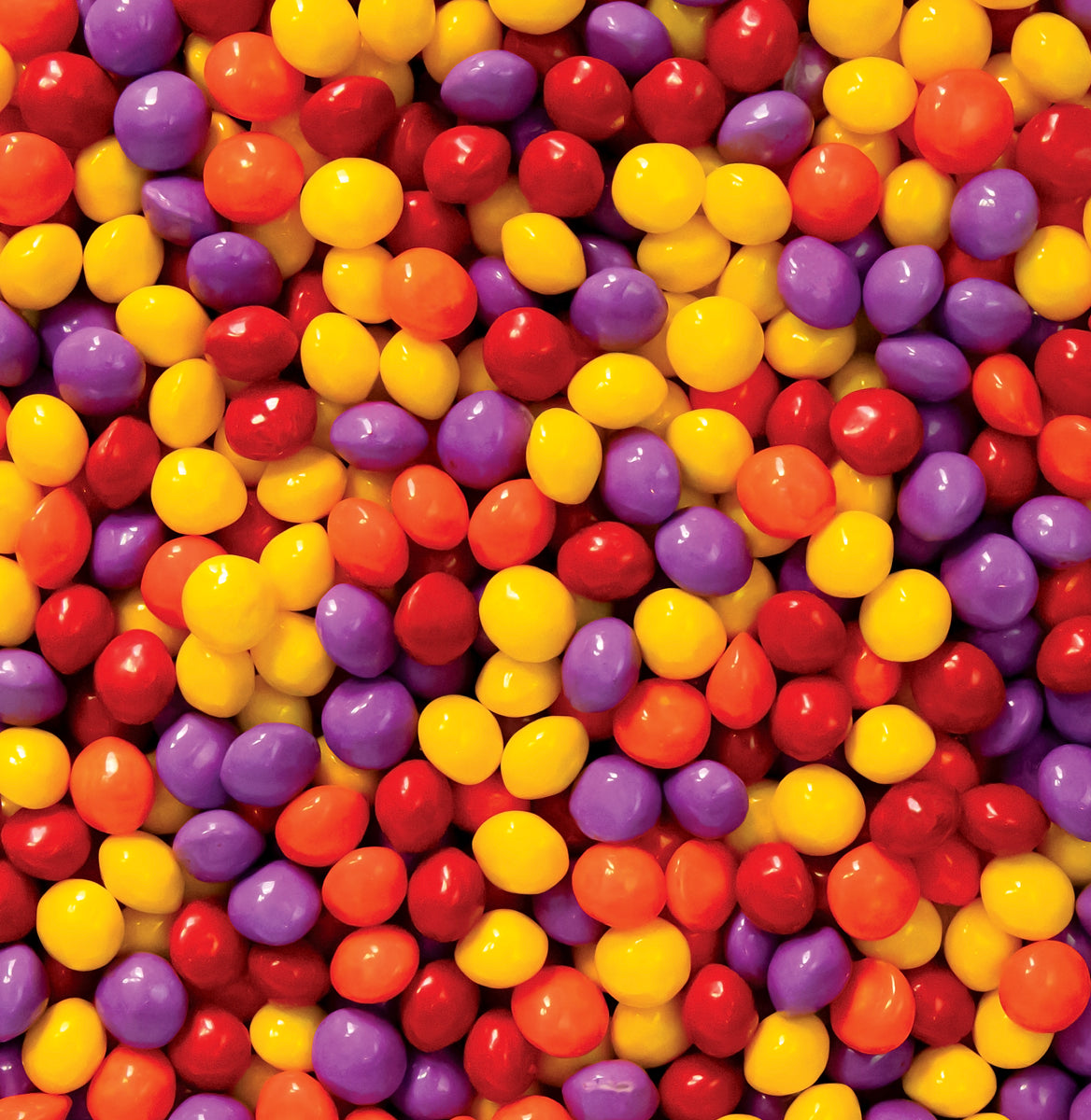 Colorful assortment of Joy Bombs Original Fruit hemp chews, featuring vibrant red, yellow, purple, and orange candies.
