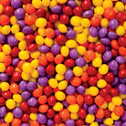Colorful assortment of Joy Bombs Original Fruit hemp chews, featuring vibrant red, yellow, purple, and orange candies.