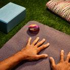 Small round tin of Camino Sours hemp-infused sour candies on yoga mat, with blue box and colorful blanket nearby.