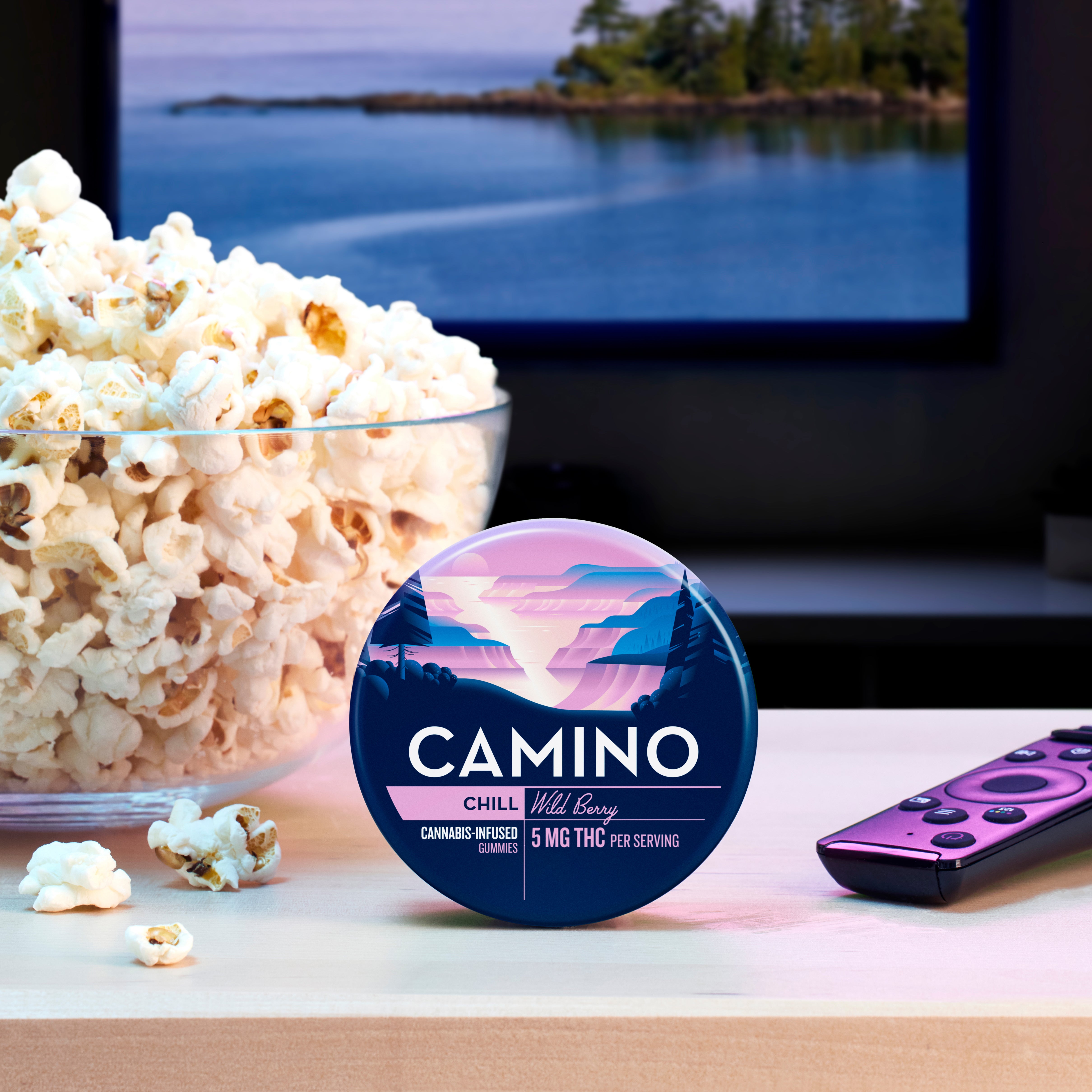 Camino Wild Berry Chill gummies with 5mg THC per serving, displayed beside a bowl of popcorn and a remote control.